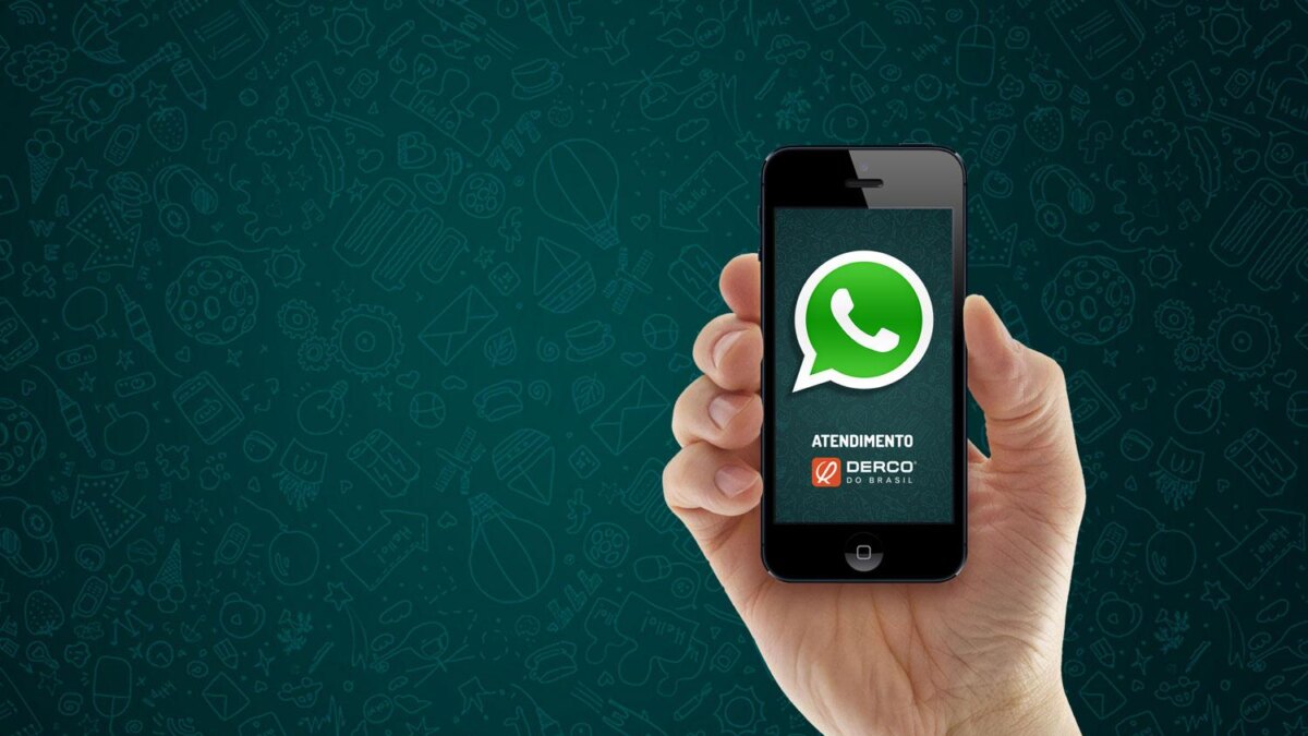 Рука держит iPhone с открытым WhatsApp на экране, наглядная иллюстрация мессенджера