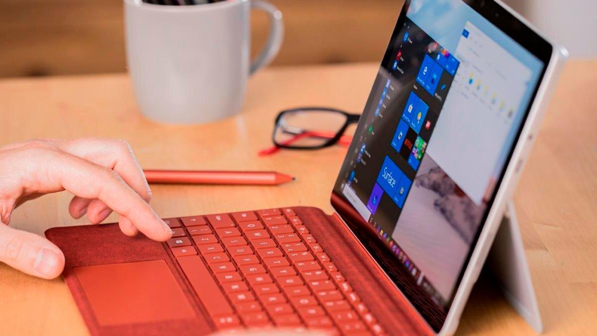 Microsoft Surface с красной клавиатурой и экраном с интерфейсом Windows в обзоре Surface Go 2
