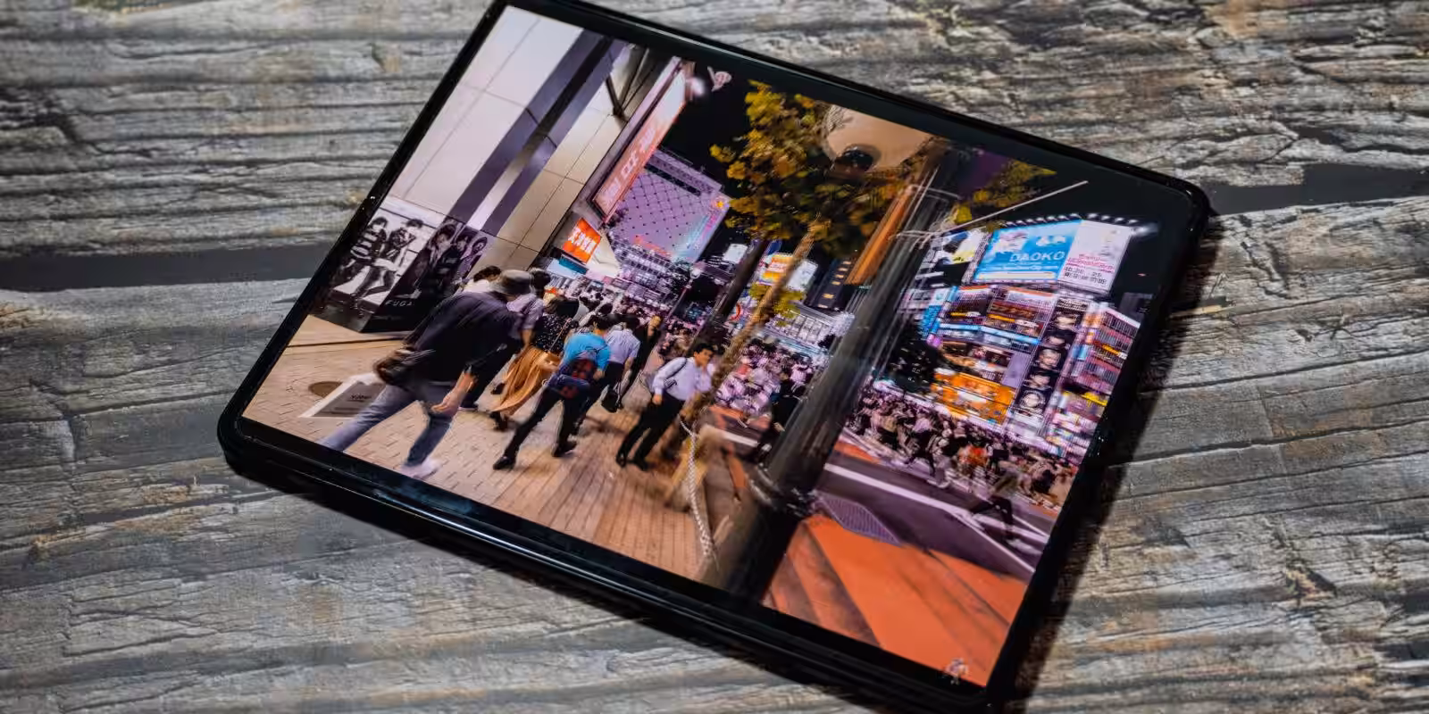 Складной смартфон Samsung Galaxy Z Fold3 на поверхности с деревом