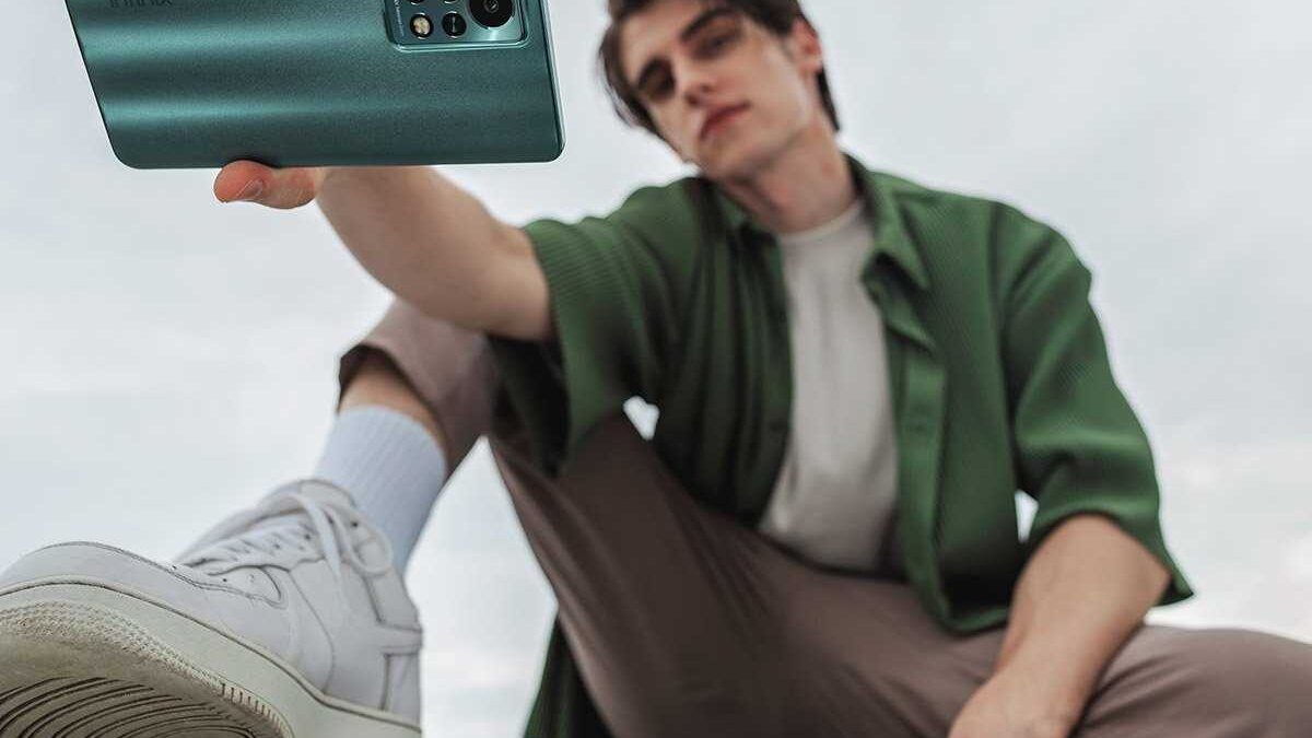 Человек фотографирует смартфон Infinix Note 11S крупным планом