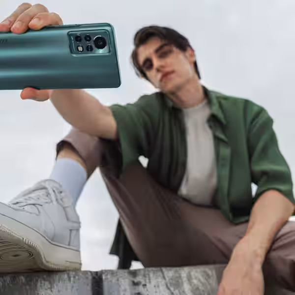 Человек фотографирует смартфон Infinix Note 11S крупным планом