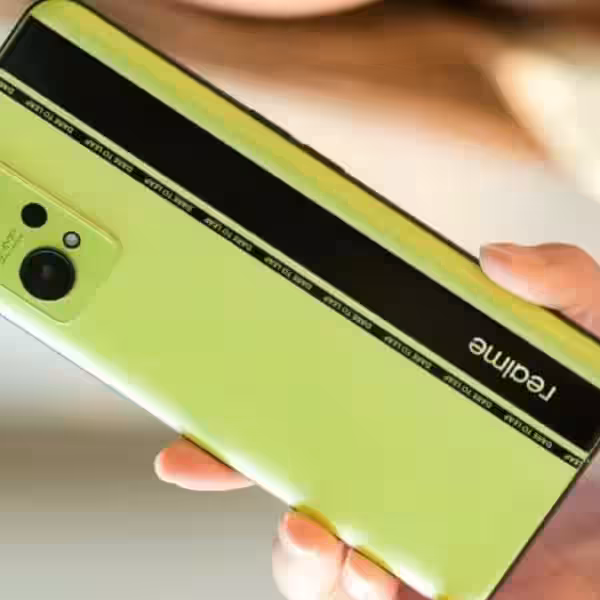 Ярко-зеленый смартфон Realme GT Neo3: вид сзади на руке