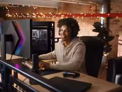 Геймер за столом с ПК HP и игровым контроллером, двухэкранная установка с RGB-подсветкой