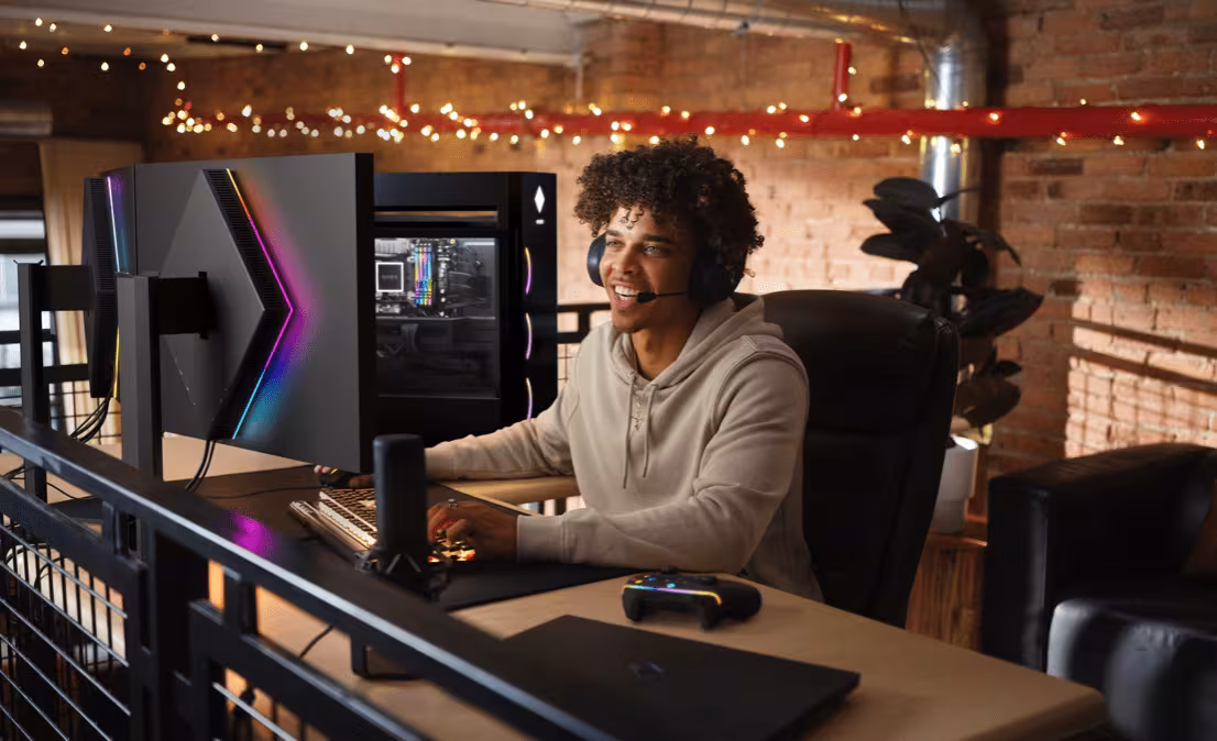 Геймер за столом с ПК HP и игровым контроллером, двухэкранная установка с RGB-подсветкой