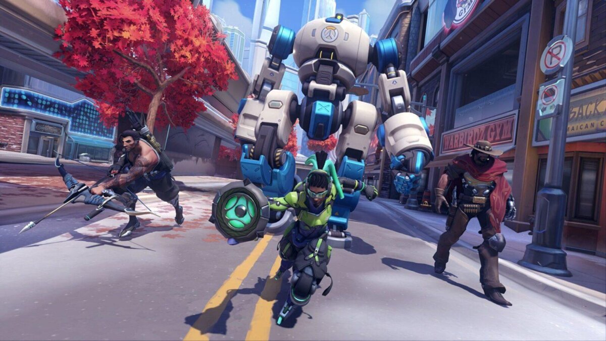 игроки сражаются в игре Overwatch 2 на улицах города с яркими деревьями и высокими зданиями