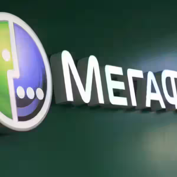 Вывеска «Мегафон» с логотипом и разделенным цветами знаком, рядом графика улыбки