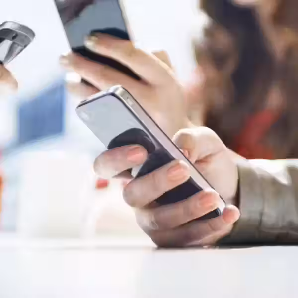 Друзья на встрече используют смартфоны, держат устройства на столе