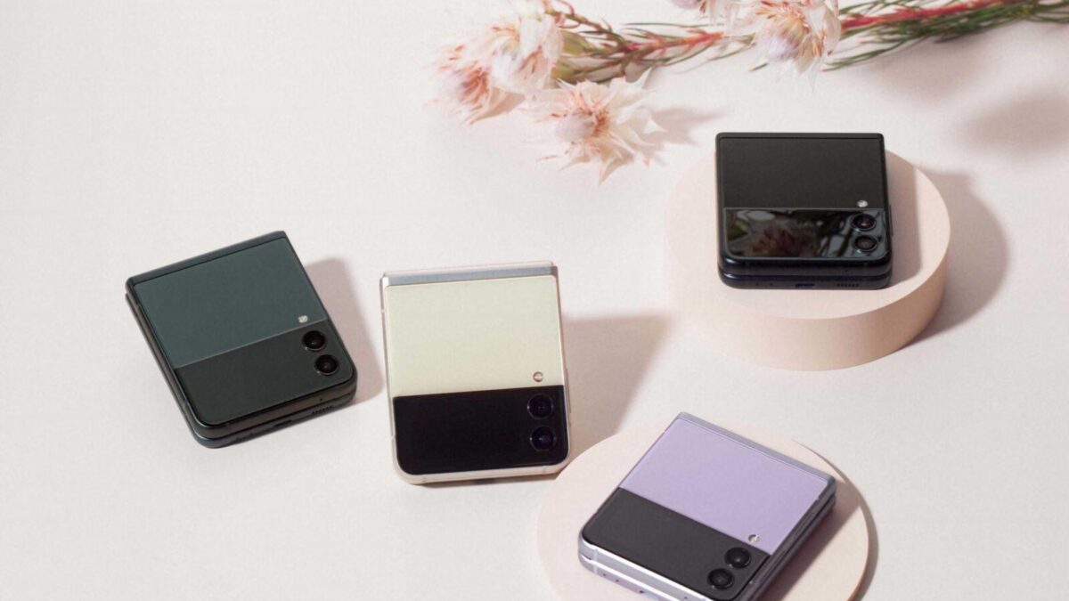 Четыре раскладных смартфона Samsung Galaxy Z Flip 4 на белом фоне с цветными панелями и цветами