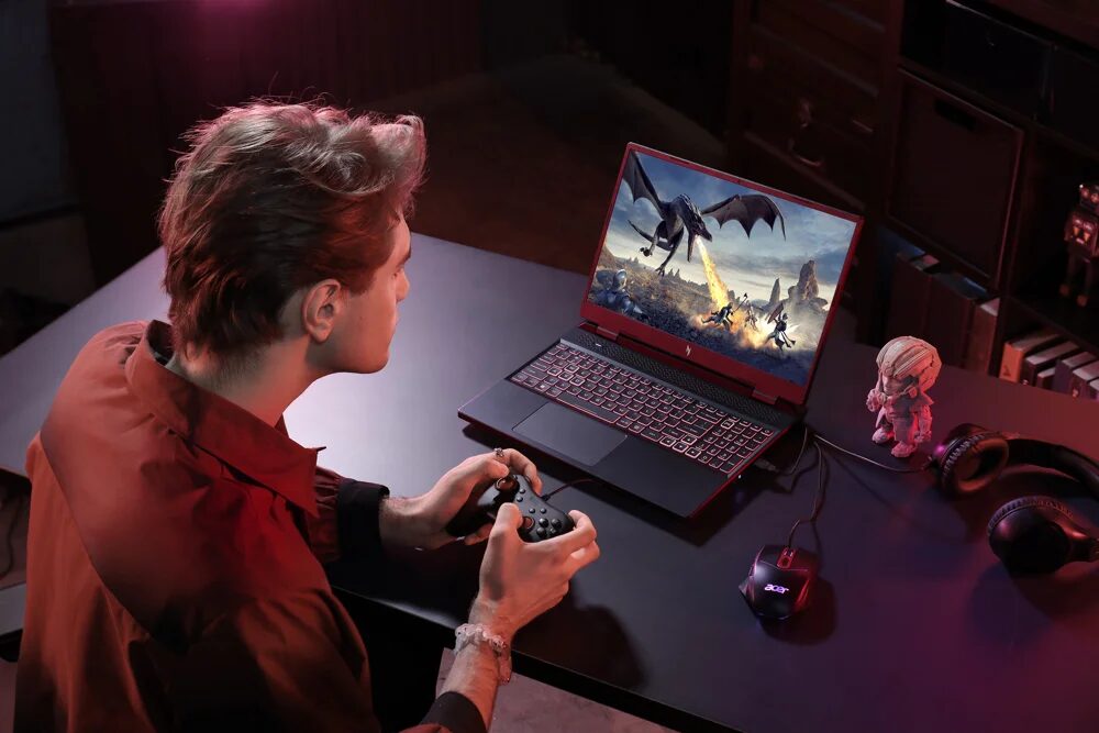 Игрок с геймпадом перед ноутбуком Acer Nitro с изображением дракона на экране
