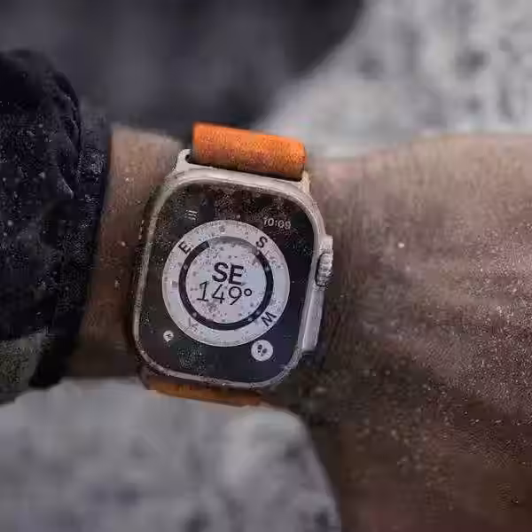 Apple Watch Ultra с дисплеем и фирменным корпусом Apple на заднем плане