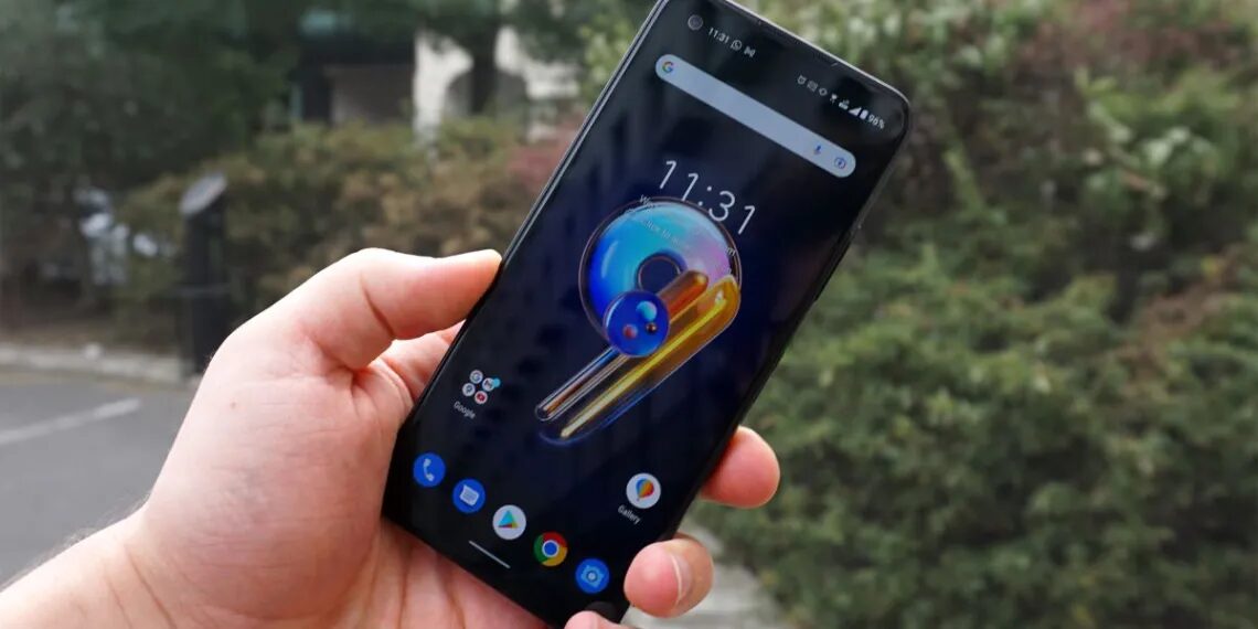 Рука держит смартфон Asus Zenfone 10 на улице