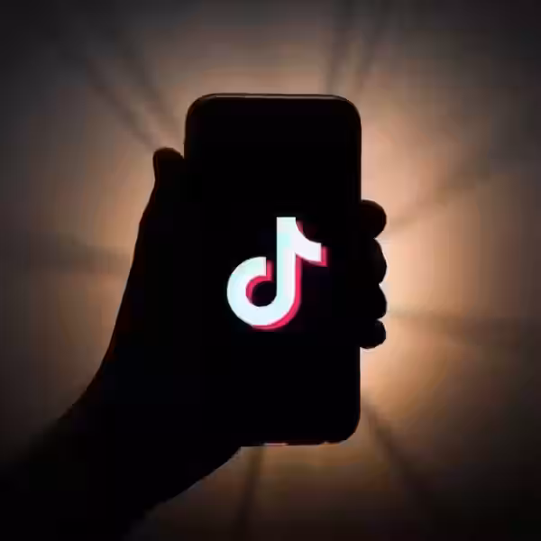 Смартфон с логотипом TikTok на экране в темной обстановке