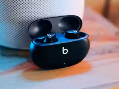 Беспроводные наушники Beats Studio Buds+ в зарядном кейсе на деревянном столе