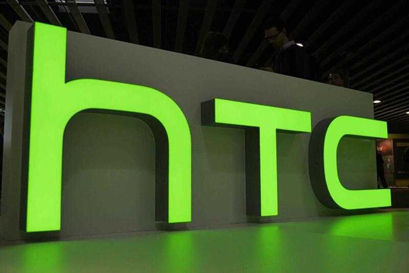 Логотип HTC на передней панели с зеленой подсветкой в интерьере смартфона HTC Wildfire E3 Lite