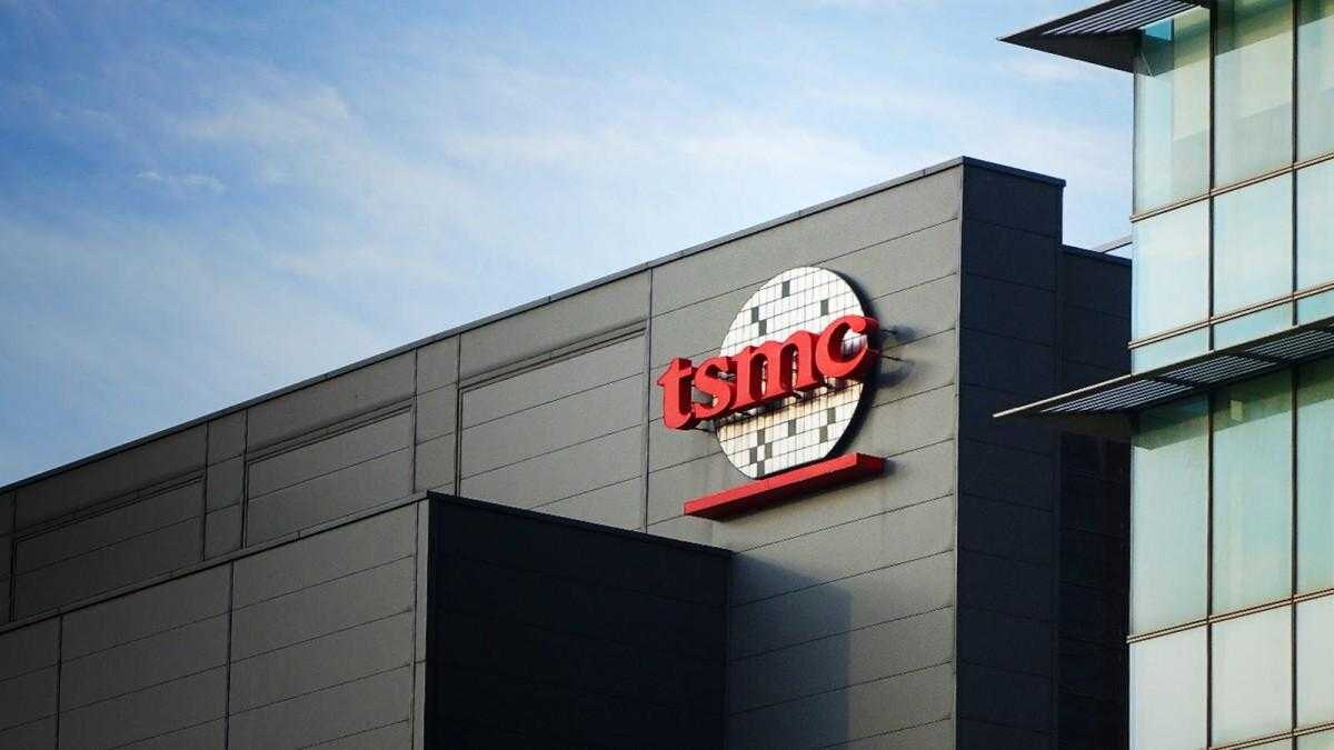 Фасад здания TSMC с логотипом компании, светлое время суток на ясном небе