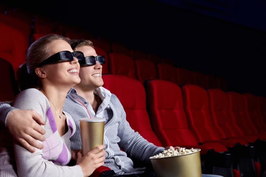 Двое зрителей в кинотеатре с 3D-очками смотрят фильм