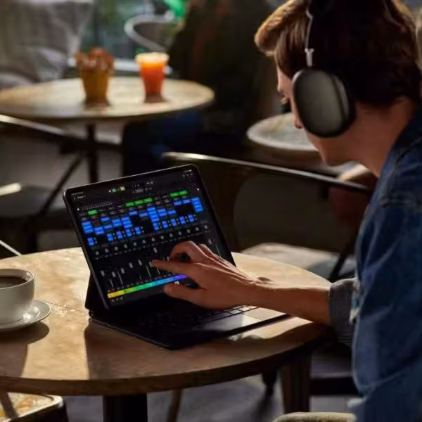 Пользователь на iPad с наушниками управляет аудиомиксом