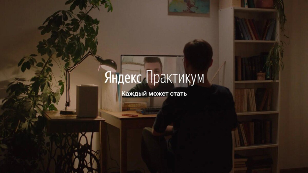 Мужчина работает за компьютером в уютной комнате с зеркалом на фоне домашнего рабочего места