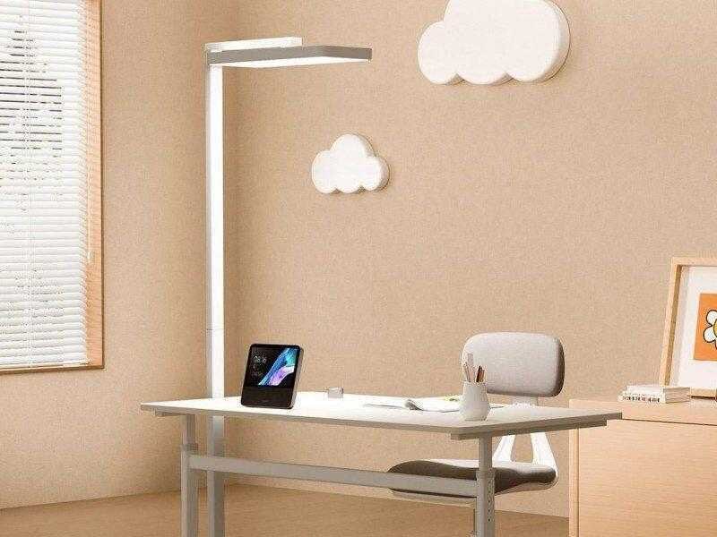 Умная лампа Mijia Vertical Learning Lamp на столе с лампой сверху и облачками на стене