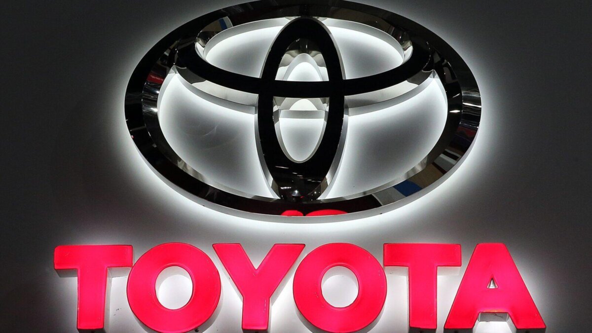 Подсвеченный логотип Toyota рядом с названием компании на фоне брендинга Toyota