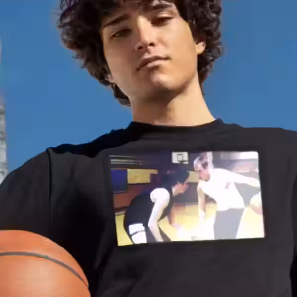 Мужчина в футболке со встроенным экраном T-Shirt TV держит баскетбольный мяч на фоне голубого неба