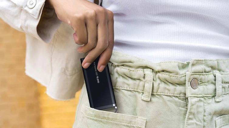 Человек вставляет портативный SSD Samsung Portable SSD T5 Evo в карман брюк