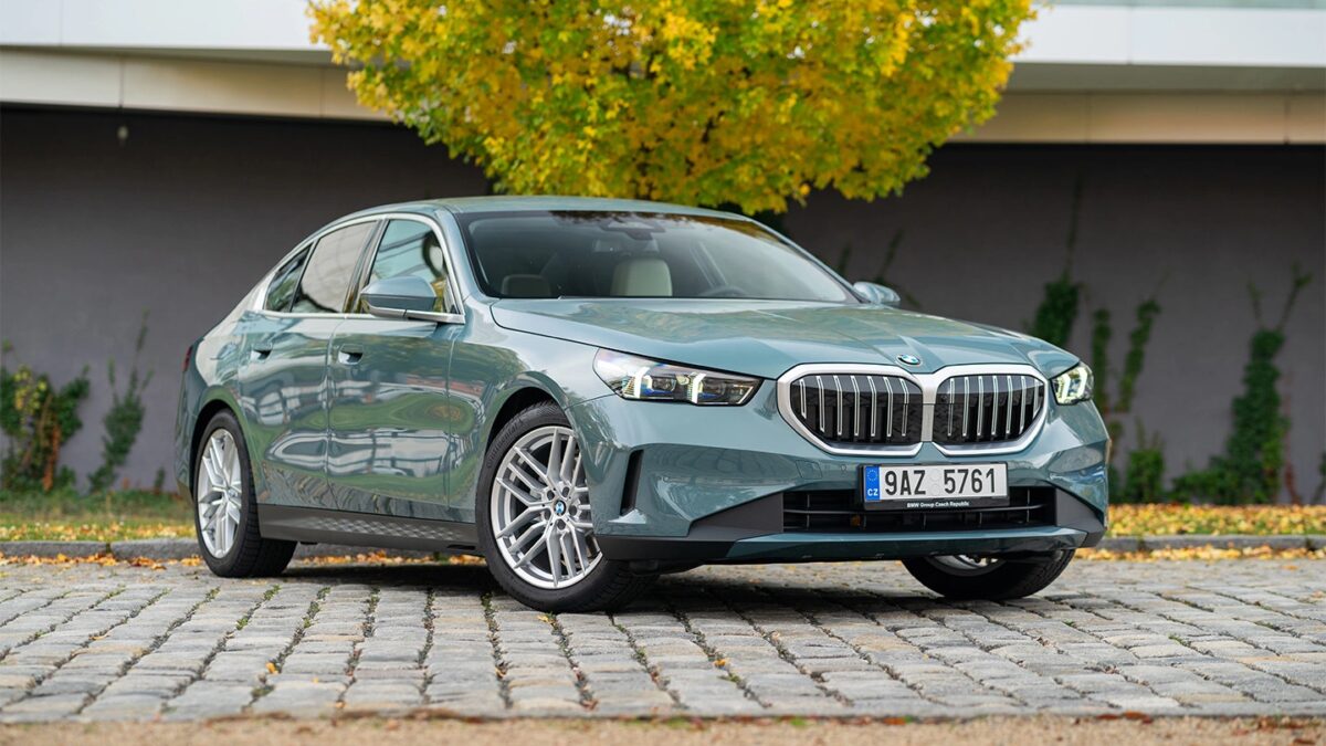 Серебристая BMW 5 Series нового поколения спереди на дороге в осенний день