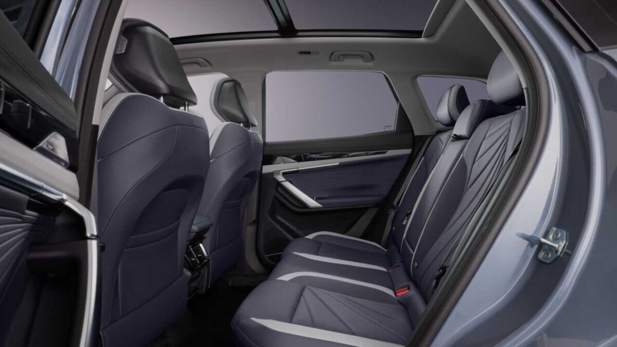 Внутренний интерьер кроссовера Geely Atlas с тёмными сиденьями