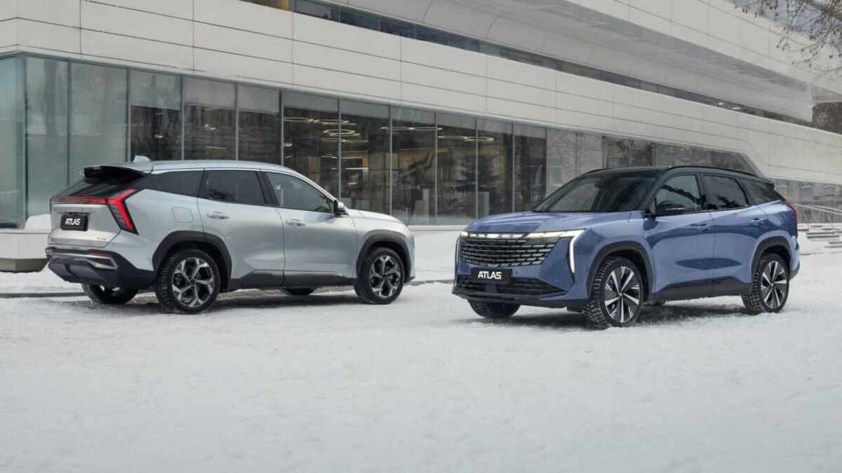 Два кроссовера Geely Atlas на снегу перед зданием