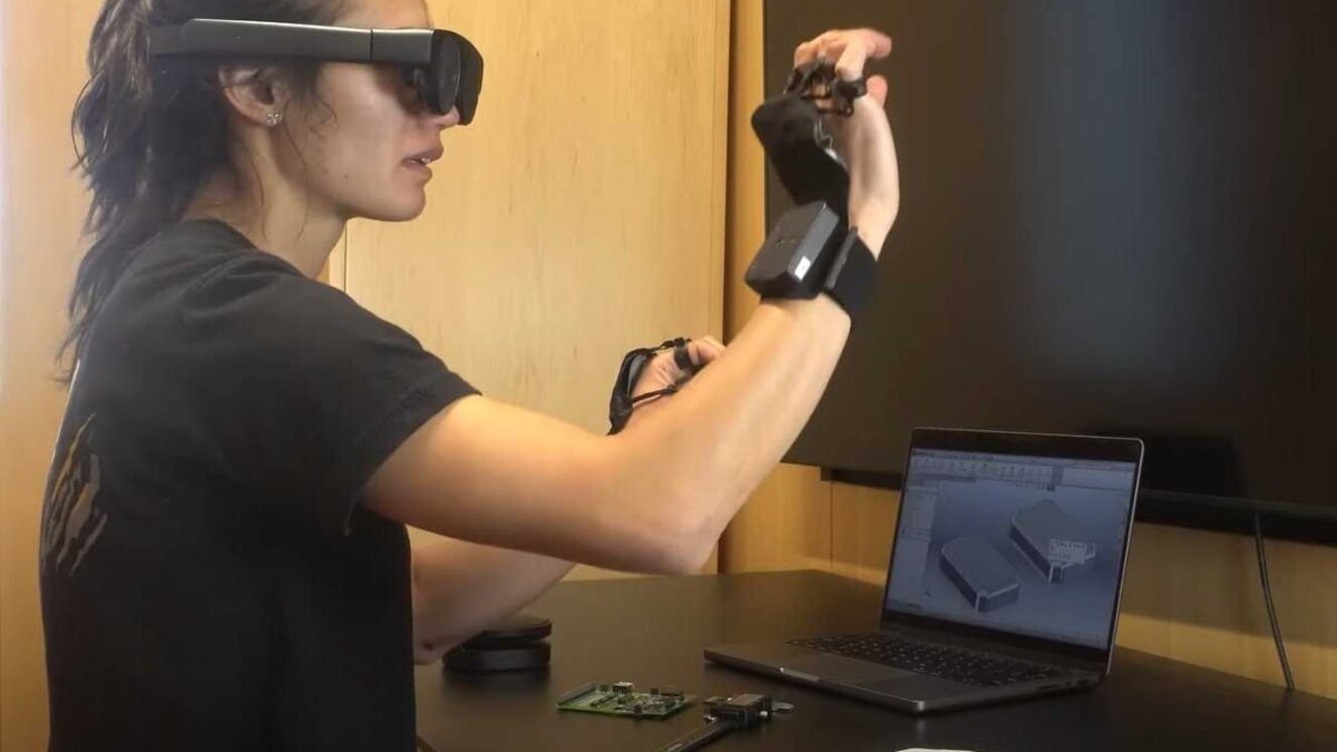 Женщина использует VR-рукавицы Phantom с компьютерной моделью на ноутбуке