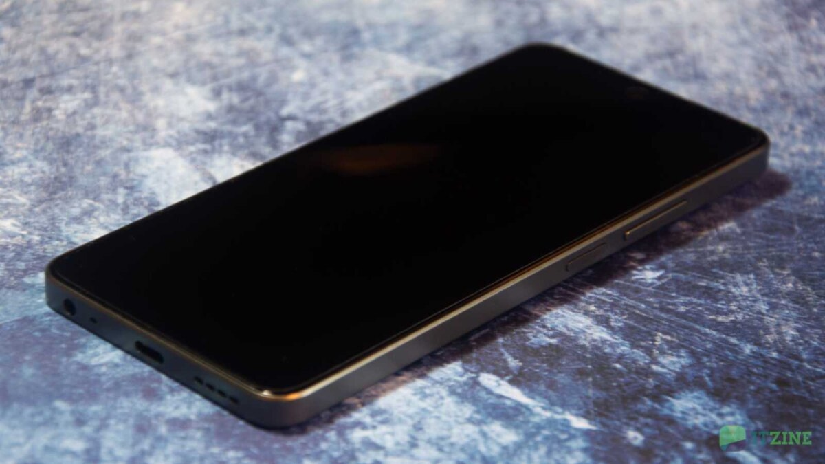 Смартфон realme C67 в тёмном корпусе на поверхности