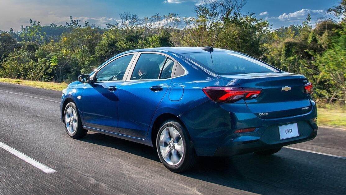Седан Chevrolet Onix движущийся по дороге на природе