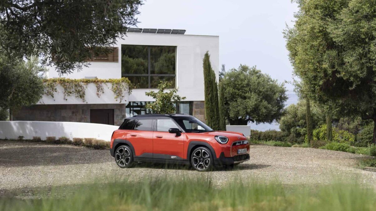 Электромобиль MINI Aceman на переднем плане на грунтовой дороге