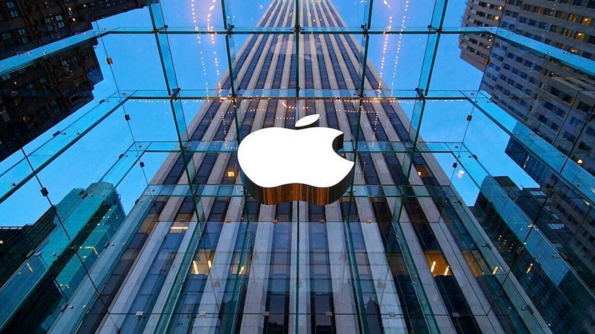 Фасад здания Apple со стеклянной стеной и логотипом компании