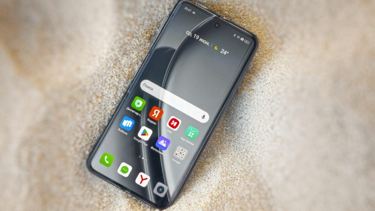 смартфон realme GT 6T частично заземлен в песке