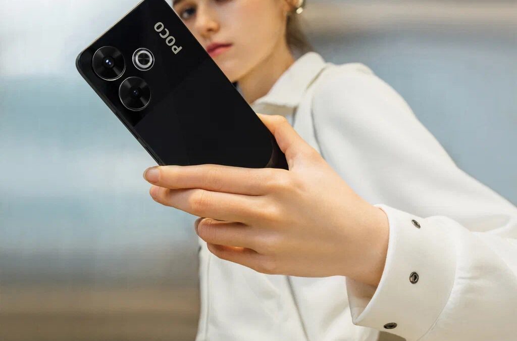 Девушка держит смартфон Poco M6 крупным планом