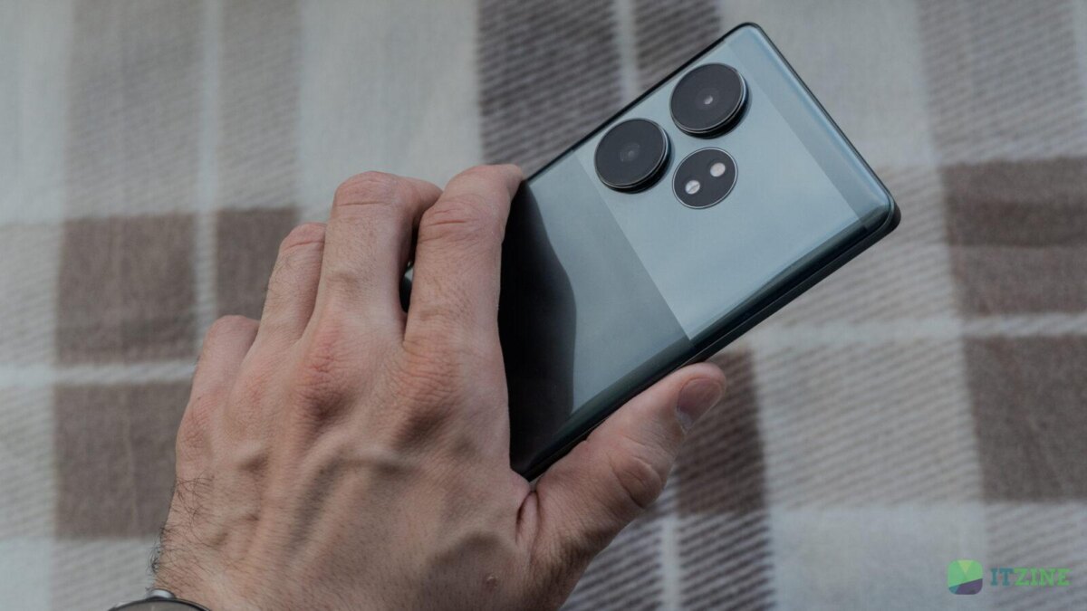 Рука держит смартфон realme GT 6T с тремя камерами сзади