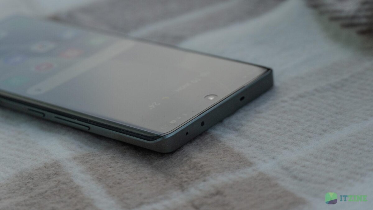 Смартфон realme GT 6T лежит на ткани, передняя панель с экраном