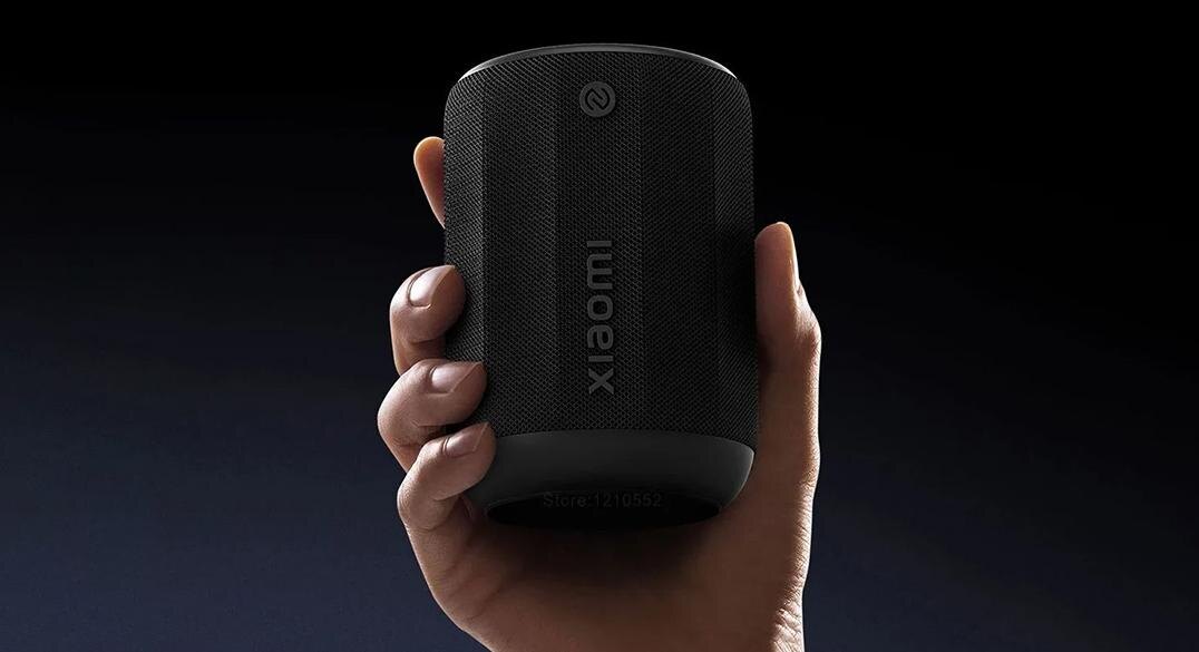Рука держит беспроводную колонку Xiaomi Speaker с черным кожухом