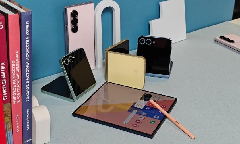 Планшет Samsung Galaxy Z Fold с стилусом и смартфонами на столе