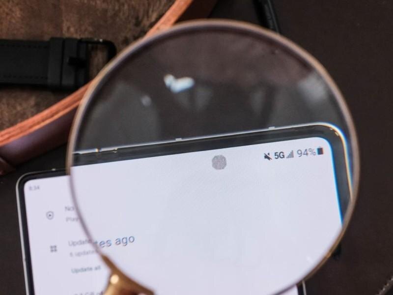 Лупа показывает часть экрана смартфона Samsung 5G с уровнем заряда 94%