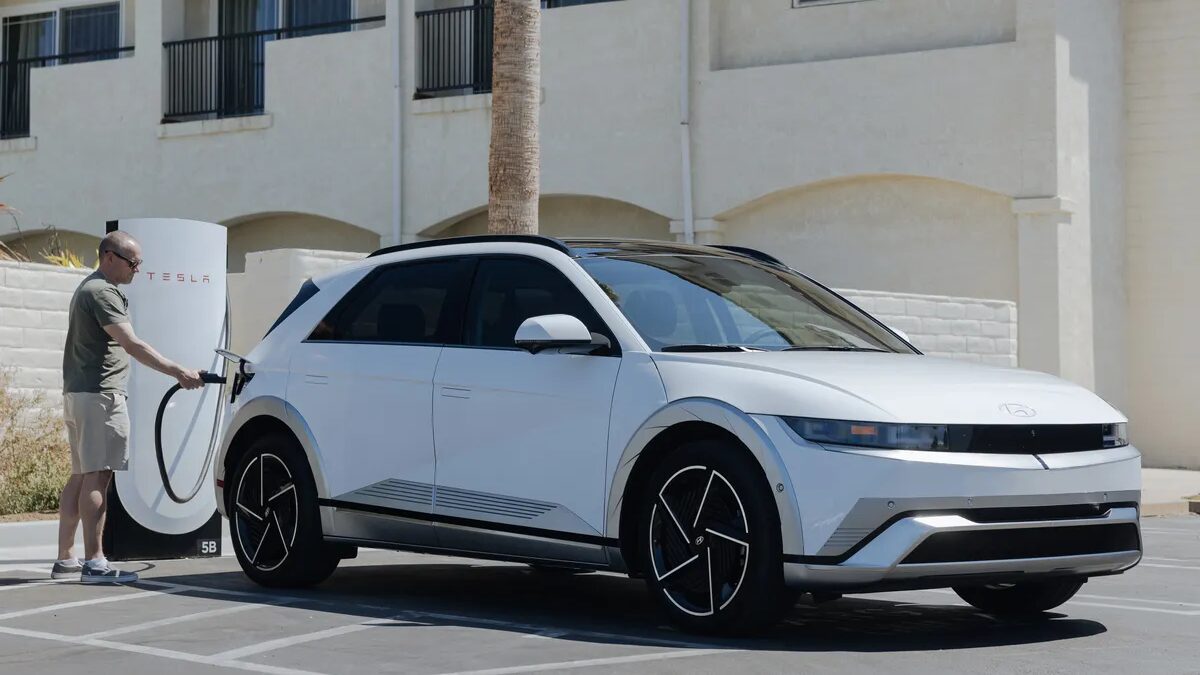 Электромобиль Hyundai Ioniq 5 2025 подключен к зарядному устройству с кабелем в парковке