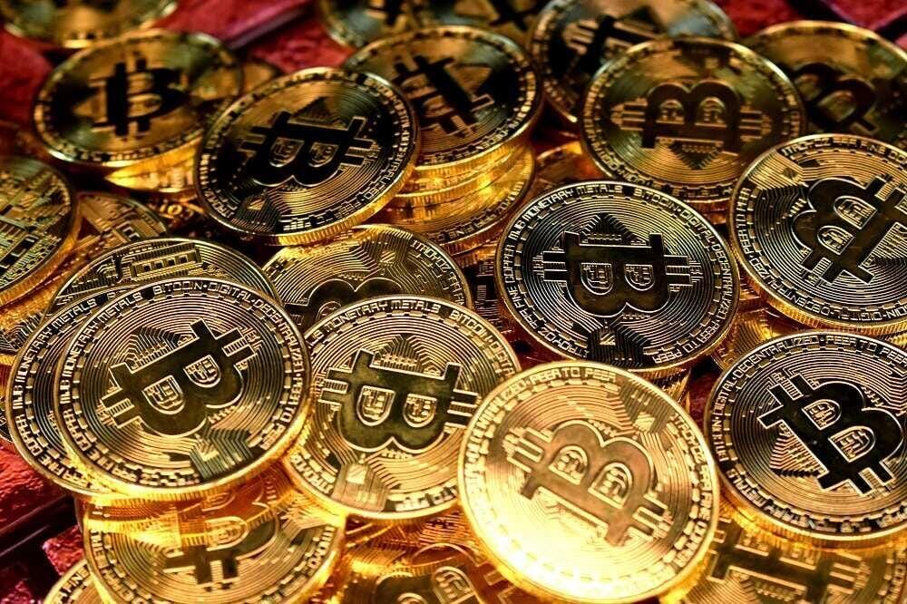 Золотые монеты с логотипом Bitcoin на фоне, символ рекордной цены $80 000