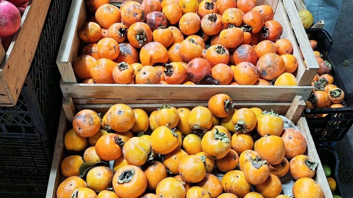 Корзина с персиками и апельсинами на рынке