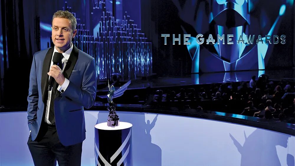 Ведущий в синем костюме на сцене на церемонии The Game Awards