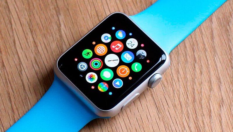 смартчасы Apple Watch с цветным дисплеем на деревянной поверхности