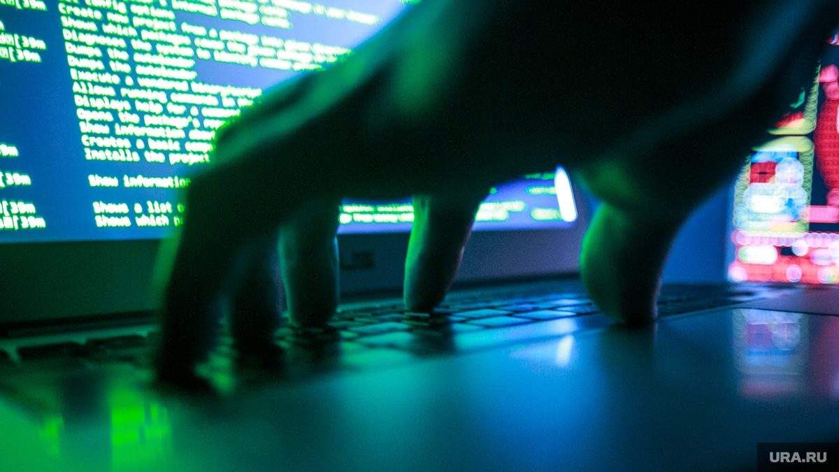 Клавиатура ноутбука перед монитором с кодом на экране