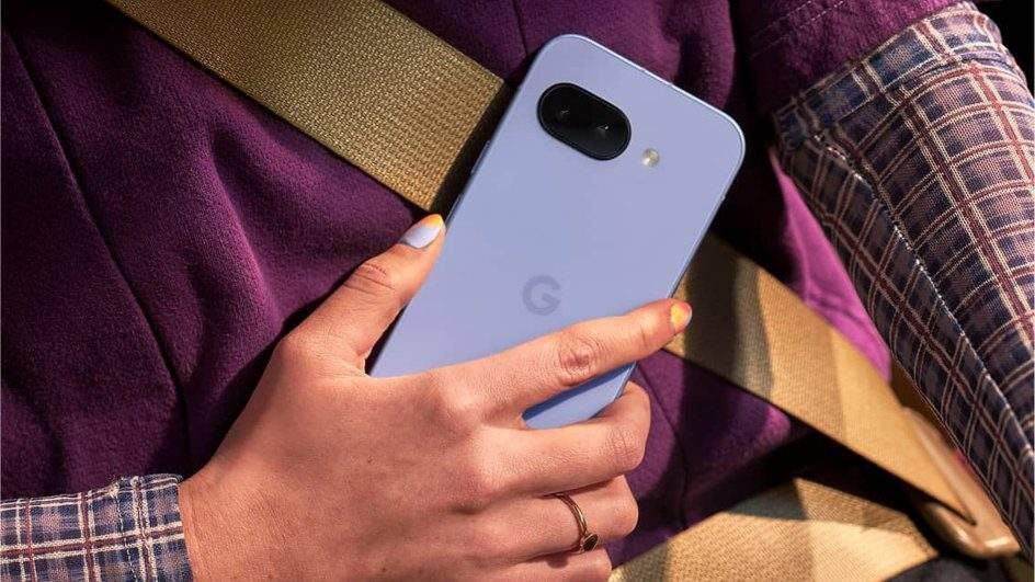 Рука держит смартфон Google Pixel 7a на фоне одежды