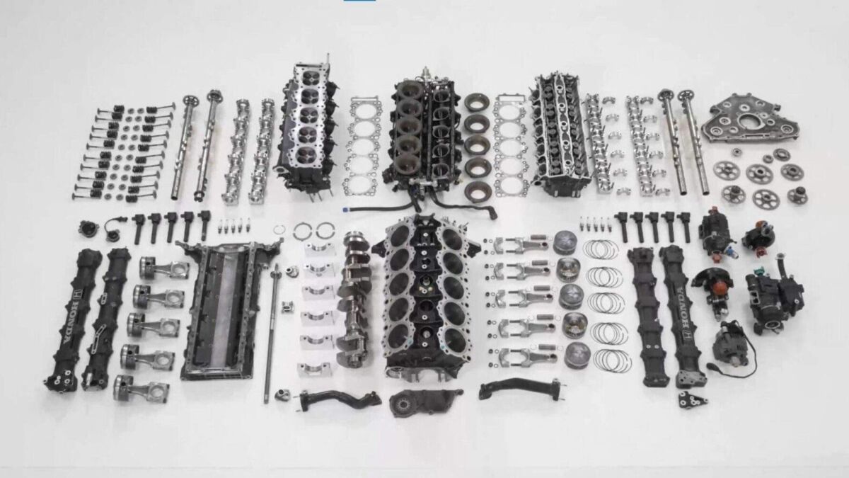 Множество разобранных деталей двигателя Формулы-1 Honda с клапанами и поршнями