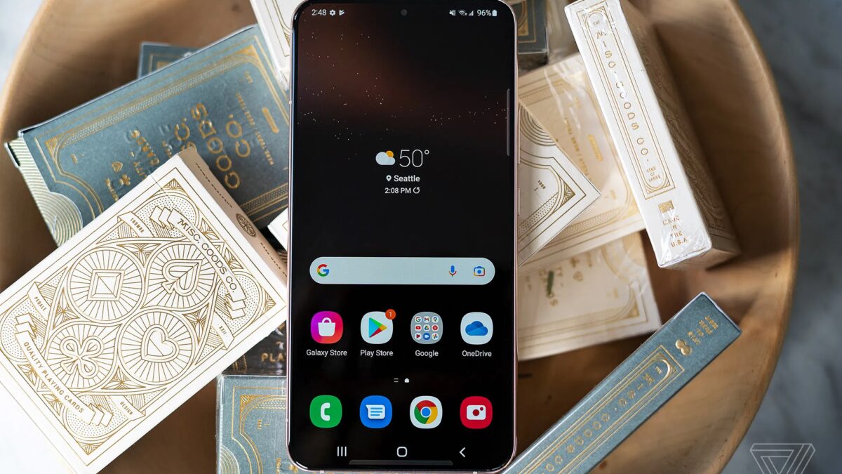 Смартфон Samsung Galaxy S22 на экране интерфейса шортс с часами и погодой